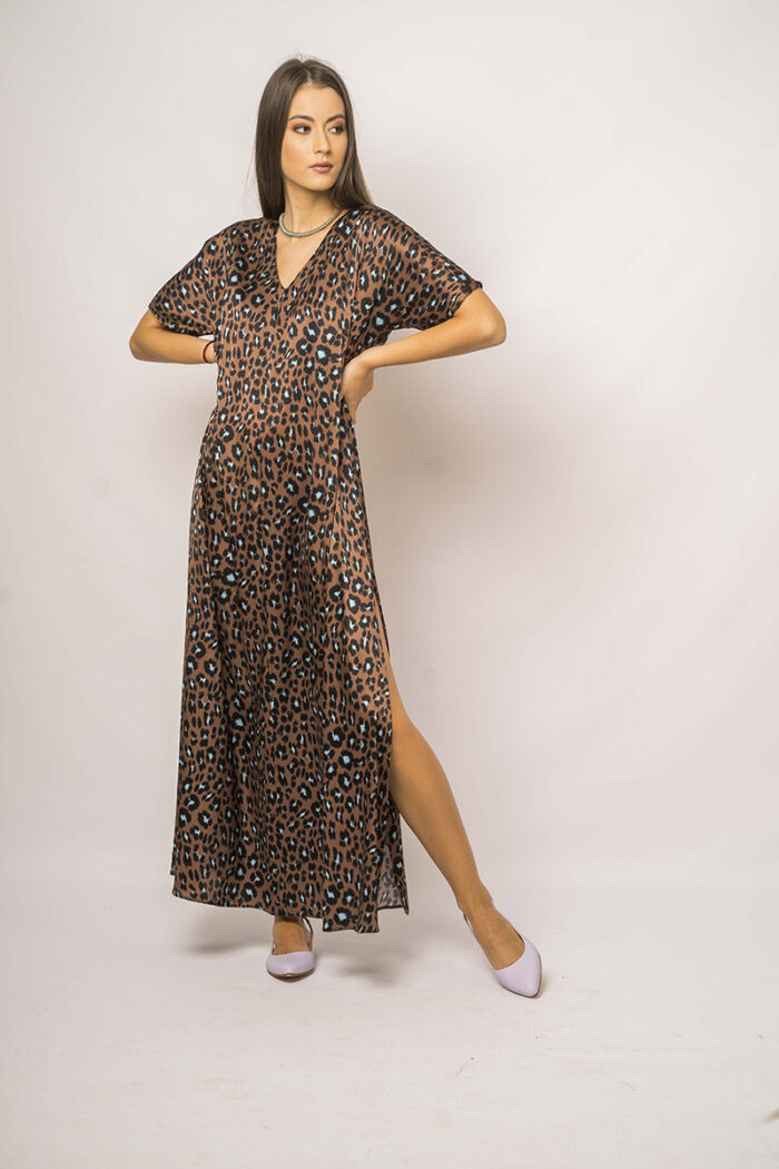 Devojka nosi dugu svilenu haljinu kratkih rukava od leopard printa.