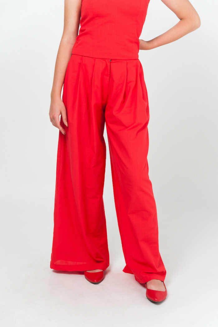 Devojka nosi crvene GALA pantalone širokih nogavica od mešavine pamuka i lena