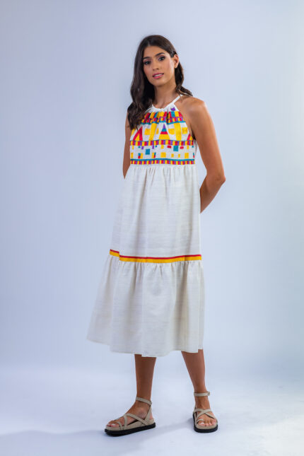Devojka nosi midi belu haljinu za leto od šantung svile sa raznobojnim lanenim detaljima.