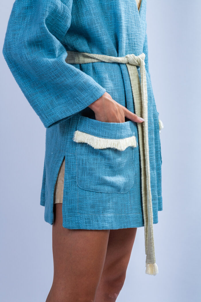 Devojka nosi plavi kardigan za leto od pamuka rustične teksture.