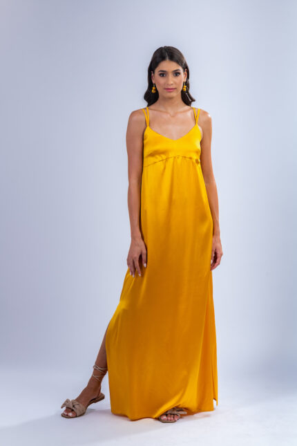 Devojka nosi dugu letnju haljinu VALERIA od žute saten svile.