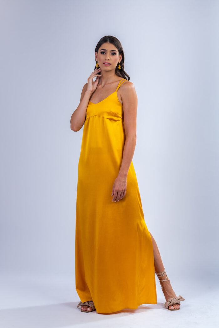 Devojka nosi dugu letnju haljinu VALERIA od žute saten svile.