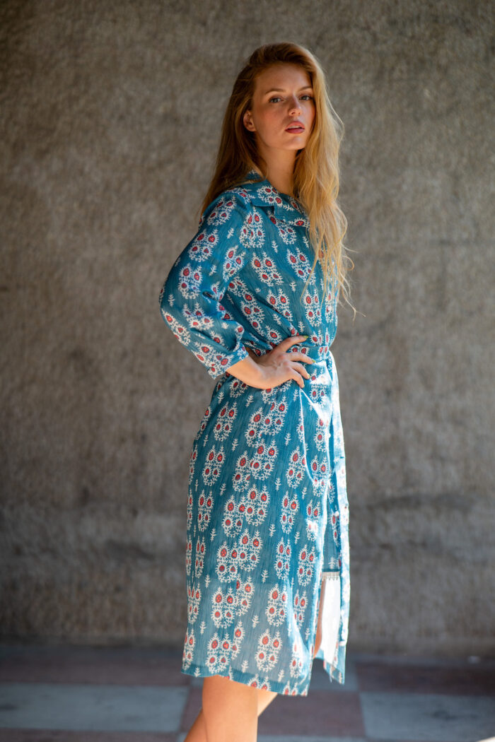 The blonde girl wears a midi ALINA dress in a blue and white vivid pattern.
