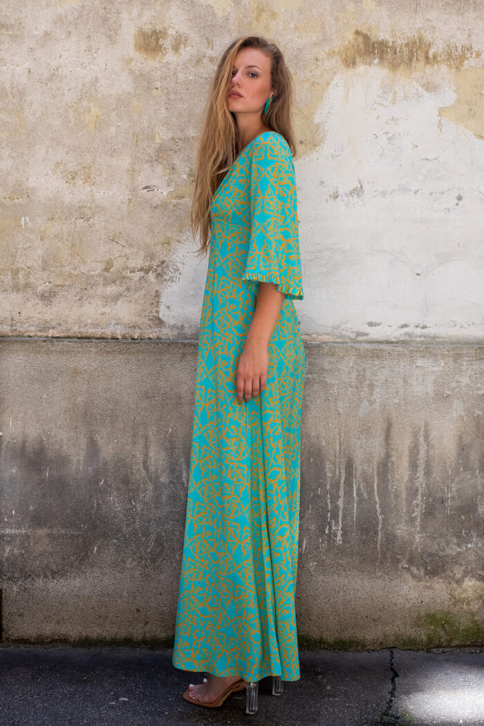 The blonde girl wears a turquoise and yellow SOFIA viscose dress with bell sleeves and a V-neckline.