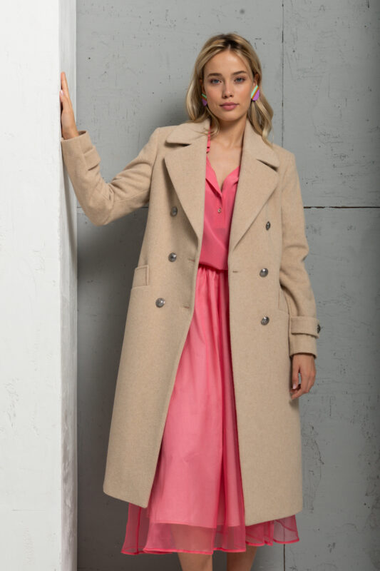 The blonde girl is wearing a long beige coat with a pink combination underneath.