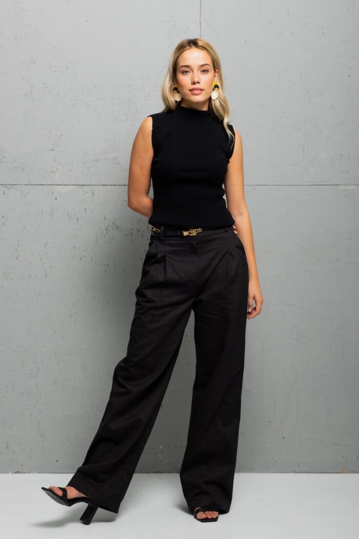 The blonde girl is wearing black cotton SONJA pants with wide legs and pleats