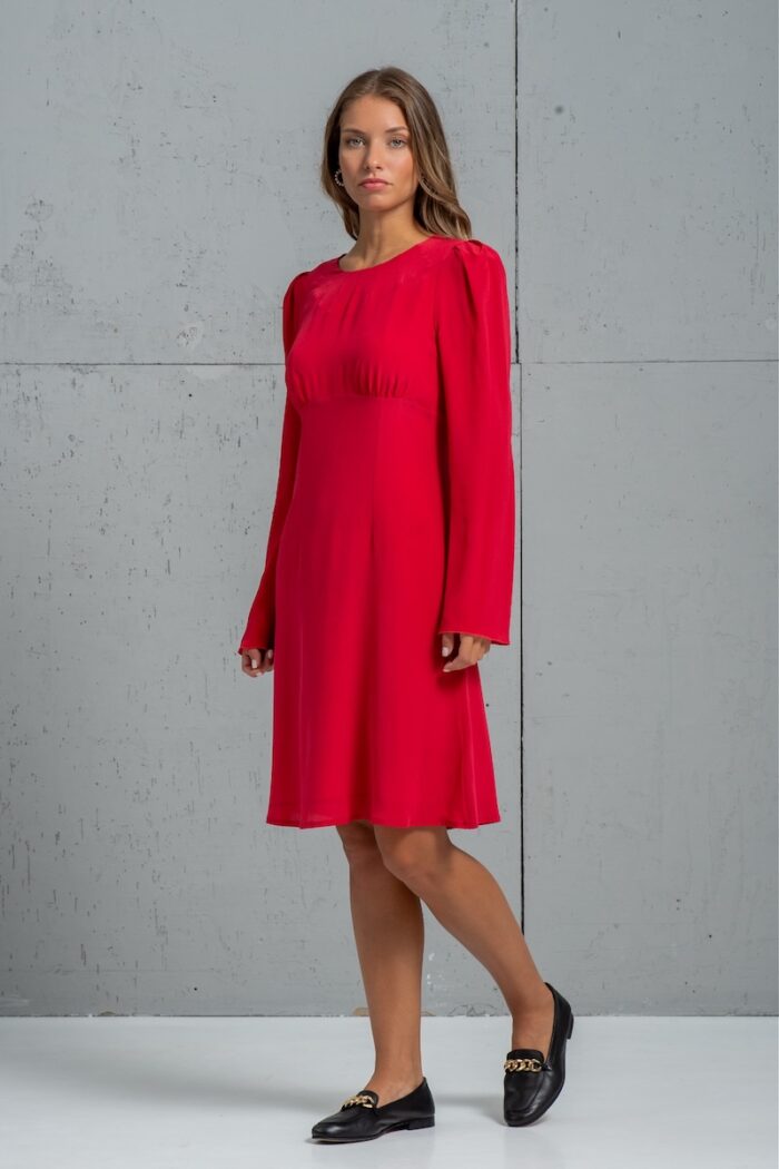 The girl is wearing a short red TEONA silk dress with long sleeves.