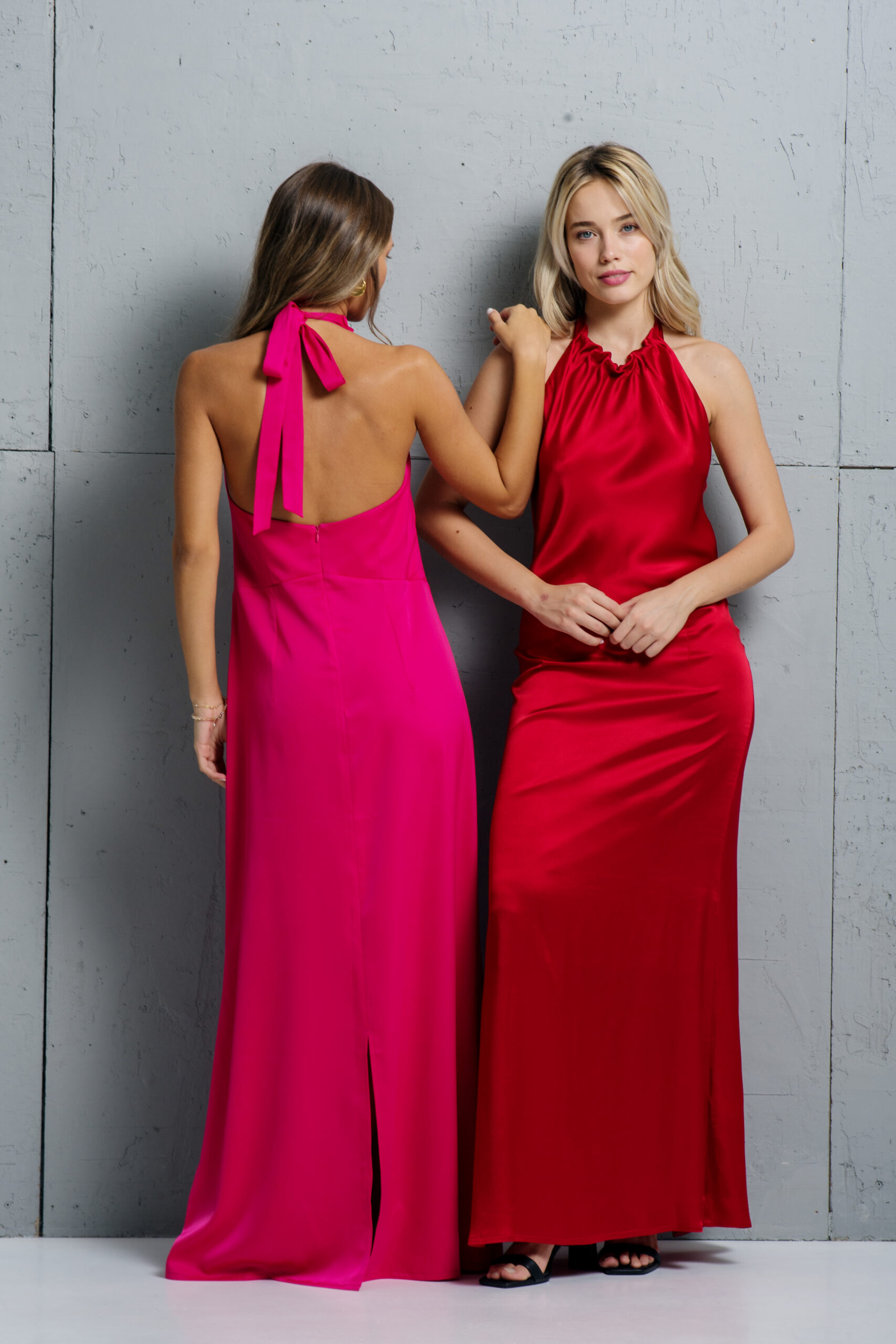 Dve devojke nose isti model haljine u crvenoj i pink boji.