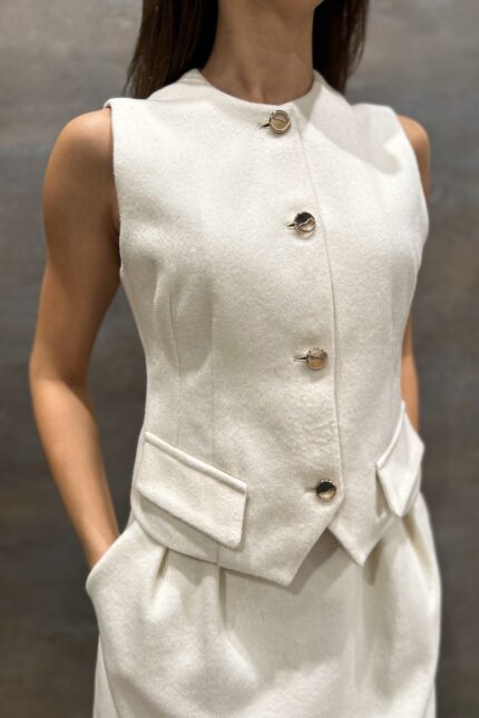 White LOU vest made of wool with golden buttons.