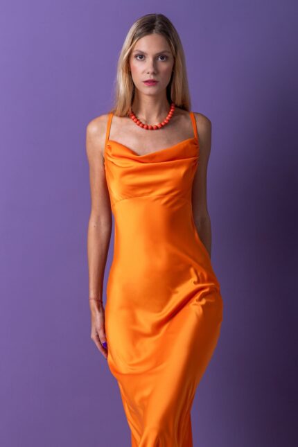 Blonde girl, long orange dress, purple background, suspenders, orange necklace