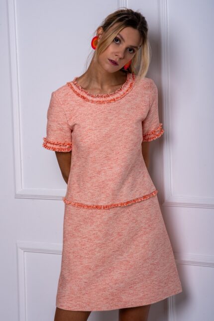 The girl wears a short VESNA dress made of orange, cotton bouclé.