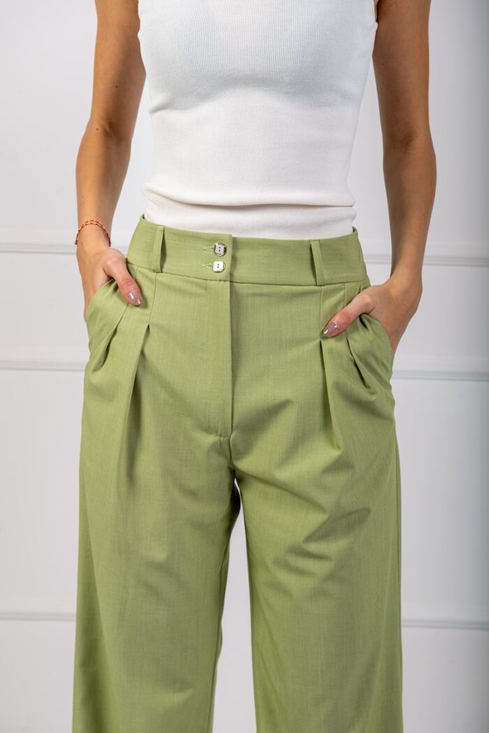 Green wide-leg pants with wide legs and a white top.